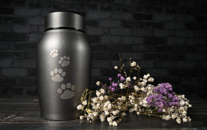 In remembrance of a pet. Pet urn beside a flower bouquet.