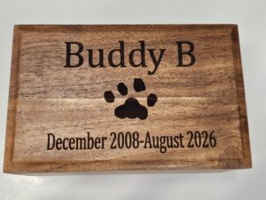 Detail view of crisp laser-engraved text and actual paw print on acacia wood urn for individual pet cremation